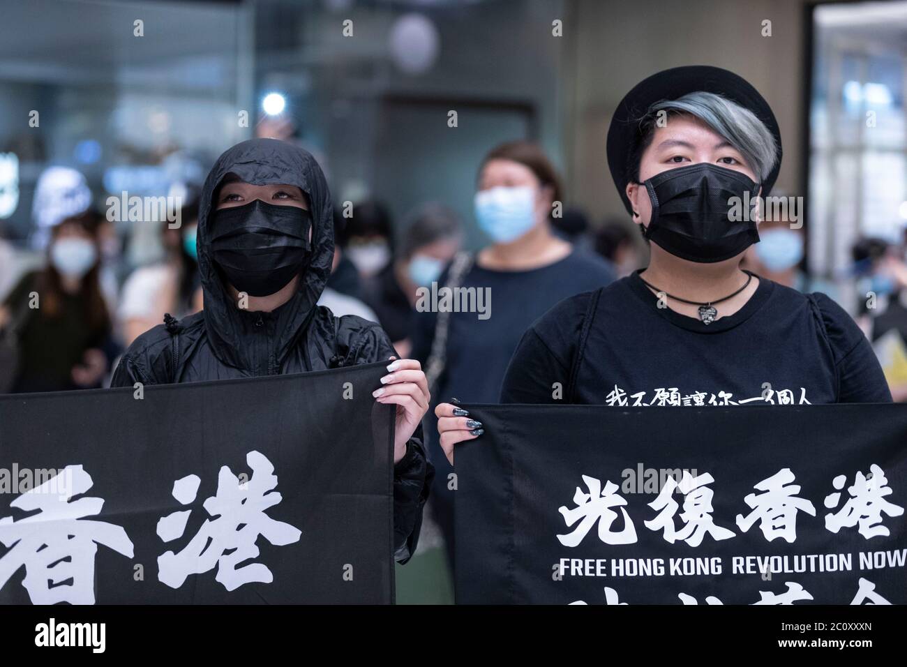 Hong Kong, Cina. 12 giugno 2020. Due manifestanti che detengono bandiere di protesta durante un raduno nel distretto di Shatin a Hong Kong il 12 giugno 2020. Migliaia di Hong Kongers hanno cantato inno di protesta e hanno cantato slogan in tutta la città il 12 giugno, in quanto hanno segnato l'anniversario di un anno di scontri importanti tra la polizia e i dimostranti pro-democrazia. Credit: May James/ZUMA Wire/Alamy Live News Foto Stock