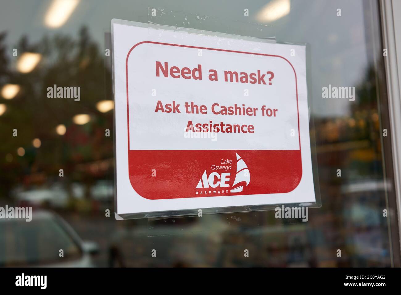 Un cartello è visibile all'ingresso del negozio Ace hardware sul lago Oswego, Oregon, che informa gli acquirenti delle maschere disponibili per coloro che non hanno la copertura del viso. Foto Stock
