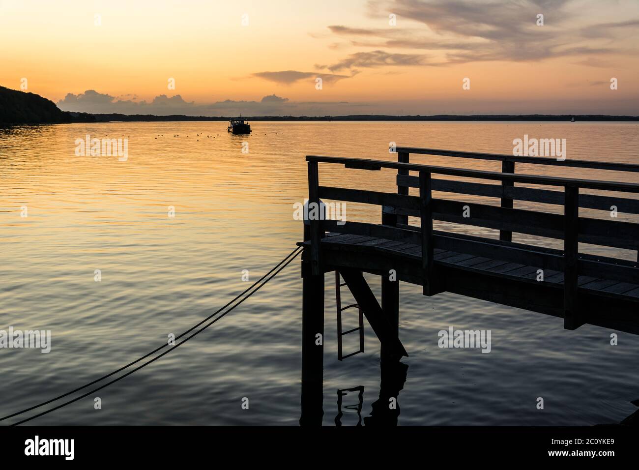 Molo in legno sul Mar Baltico durante un bellissimo tramonto colorato Foto Stock