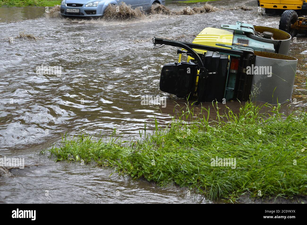 Corse in auto sotto la pioggia su una strada allagata Foto Stock