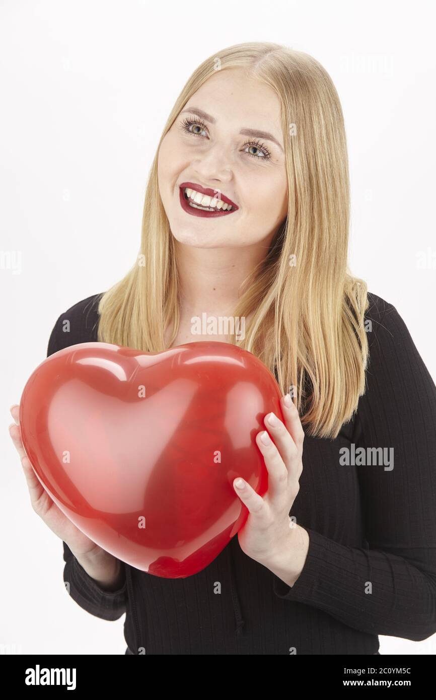 Giovane donna innamorato gioca con un cuore rosso Foto Stock