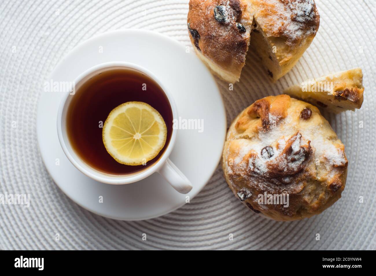 Due fatti in casa muffin alla carota con tappo di tè e limone sul tessuto bianco sfondo. vista superiore Foto Stock