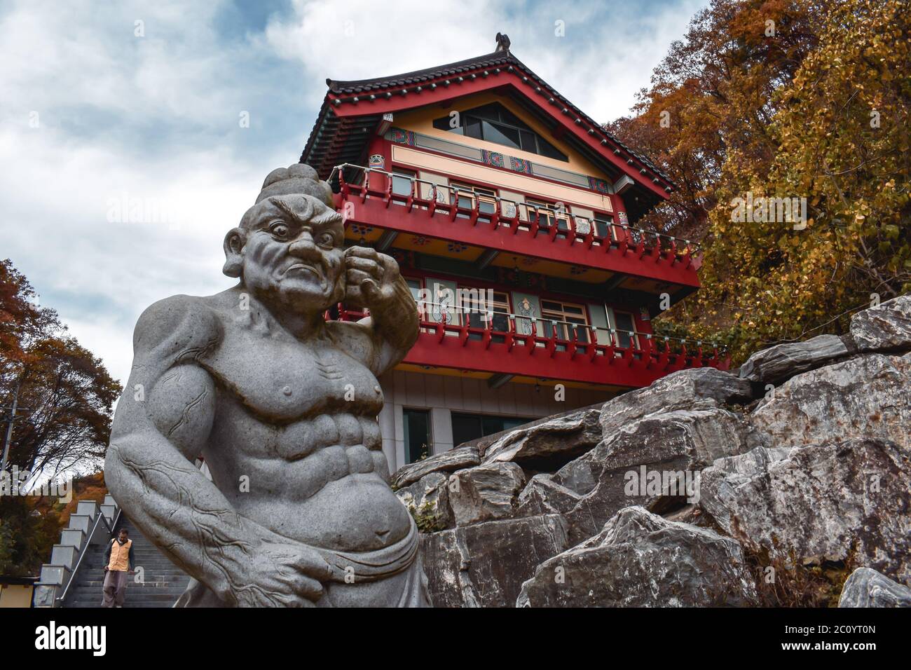 Statuto di un monaco combattente di fronte ad un edificio di tempio in legno nel tempio di Golgusa Corea del Sud Foto Stock