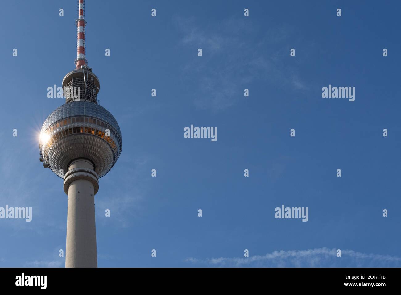 Vista parziale verticale della torre della televisione di Berlino con la punta sulla sinistra con un cielo quasi blu Foto Stock