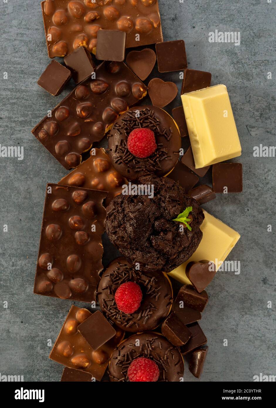 Assortimento di cioccolato bianco, scuro e al latte con noci, muffin, ciambelle Foto Stock