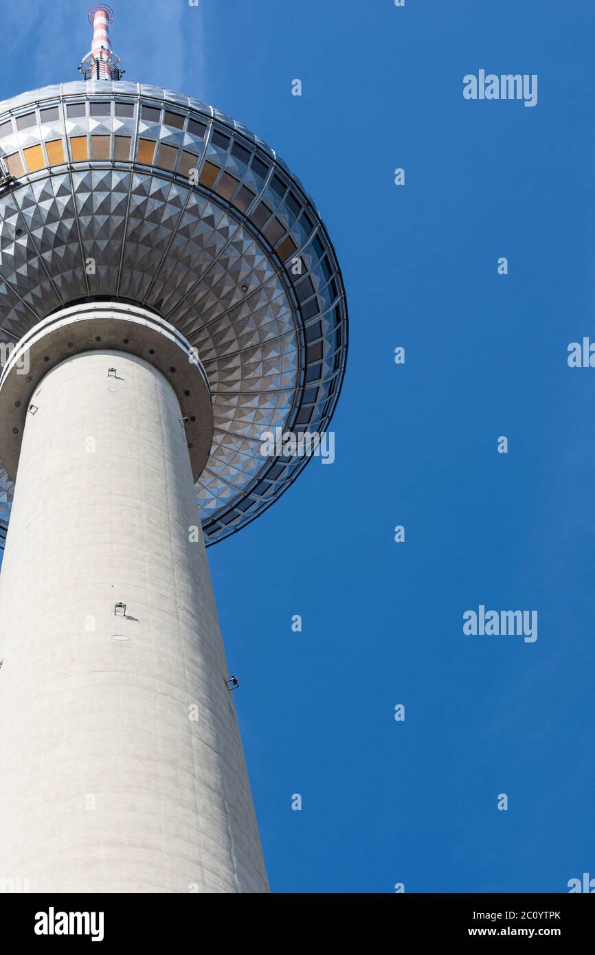 Vista parziale verticale della torre della televisione di Berlino con la punta sulla sinistra con un cielo quasi blu Foto Stock