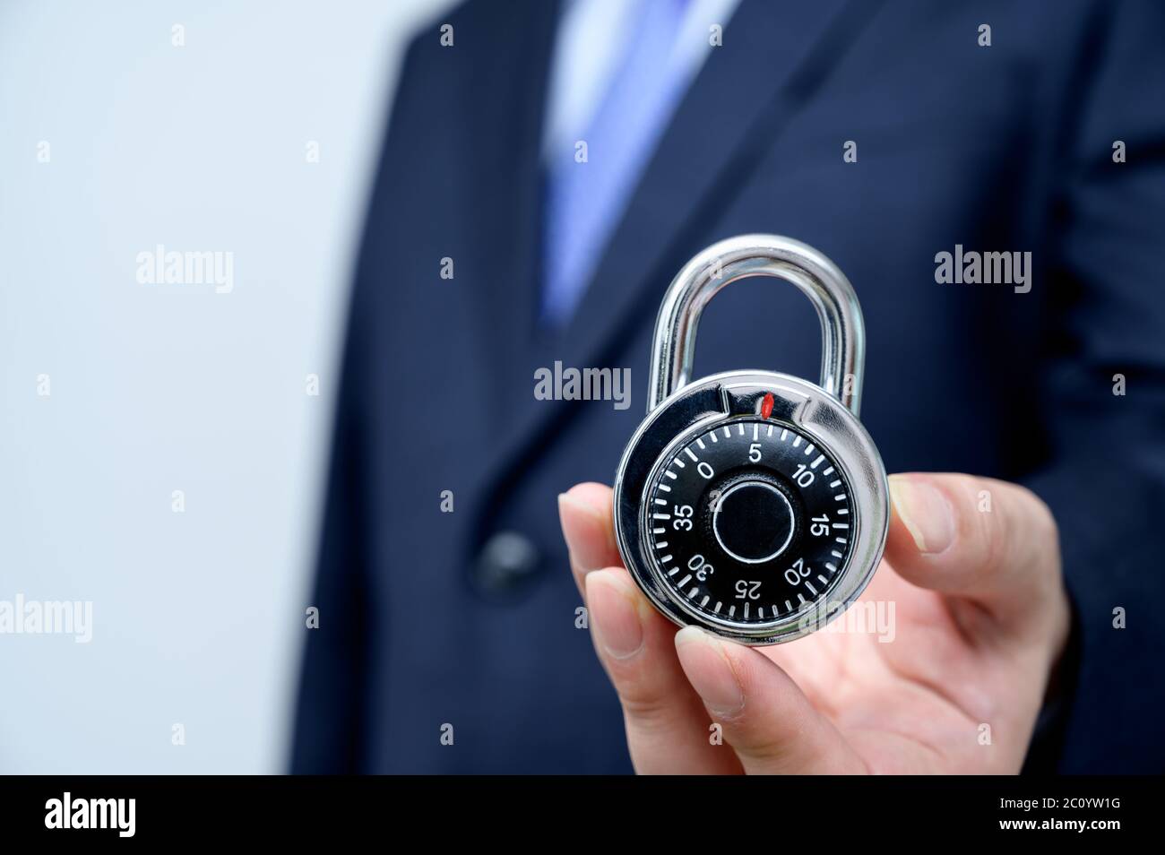 Uomo d'affari che tiene una serratura. Concetto di sicurezza aziendale. Foto Stock