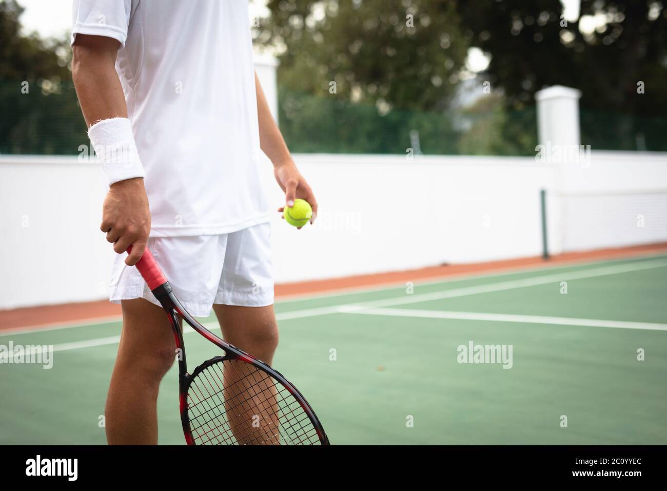 Allenamento di un uomo caucasico su un campo da tennis Foto Stock