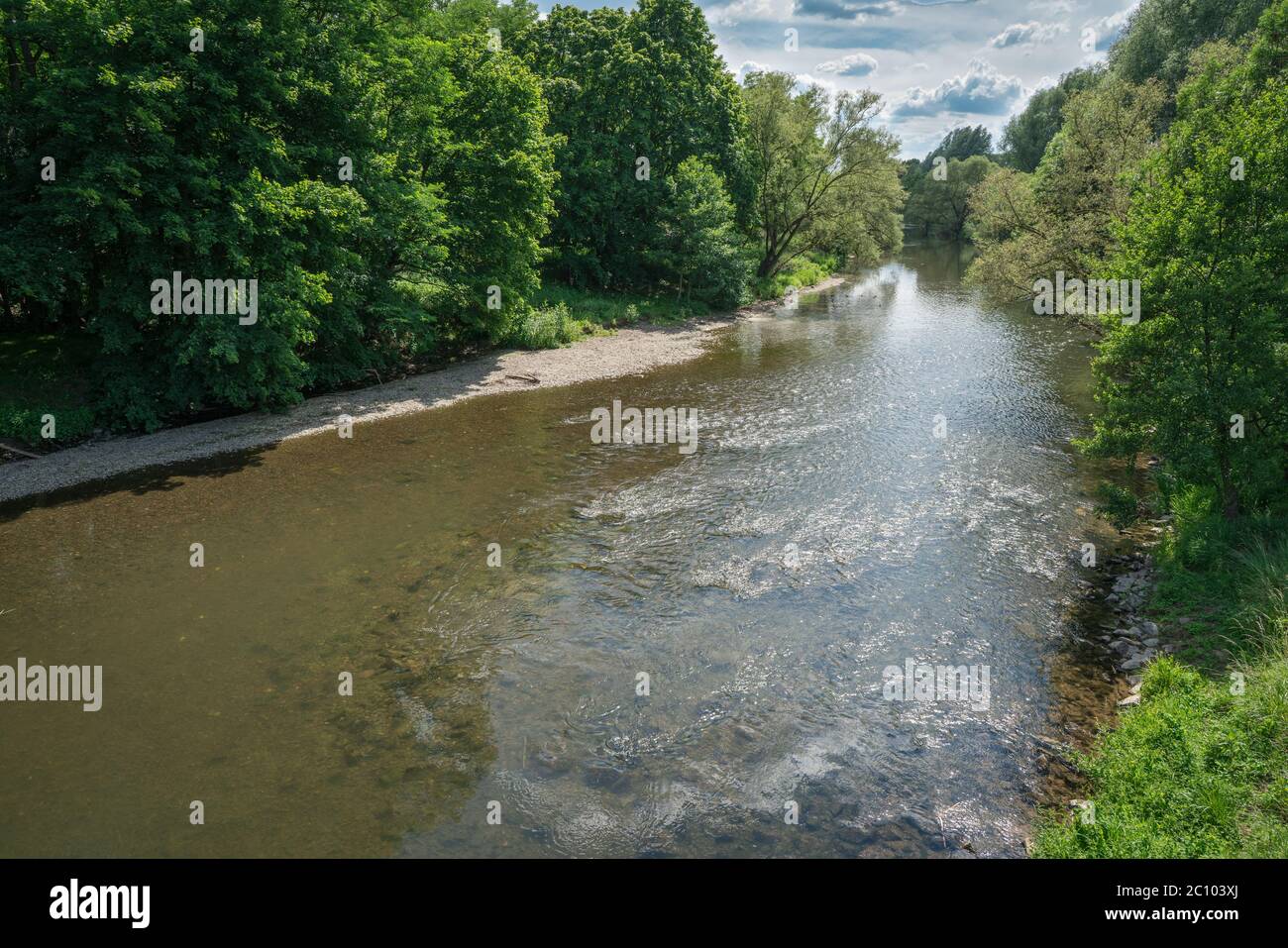 Guardando giù il fiume verso il sole con riflessi sull'acqua. Una scena in una bella giornata estiva. Foto Stock