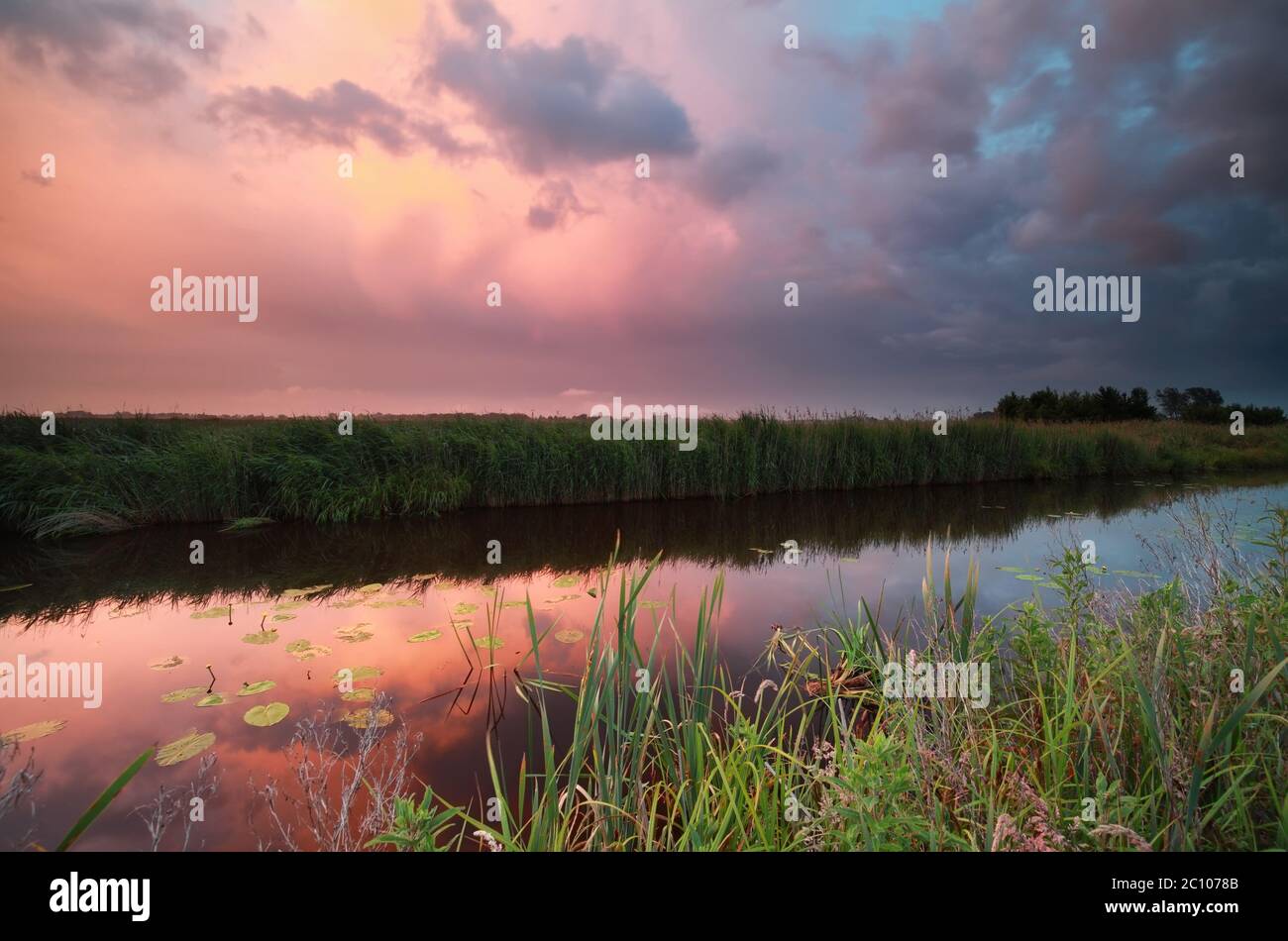 tramonto piovoso sul fiume Foto Stock