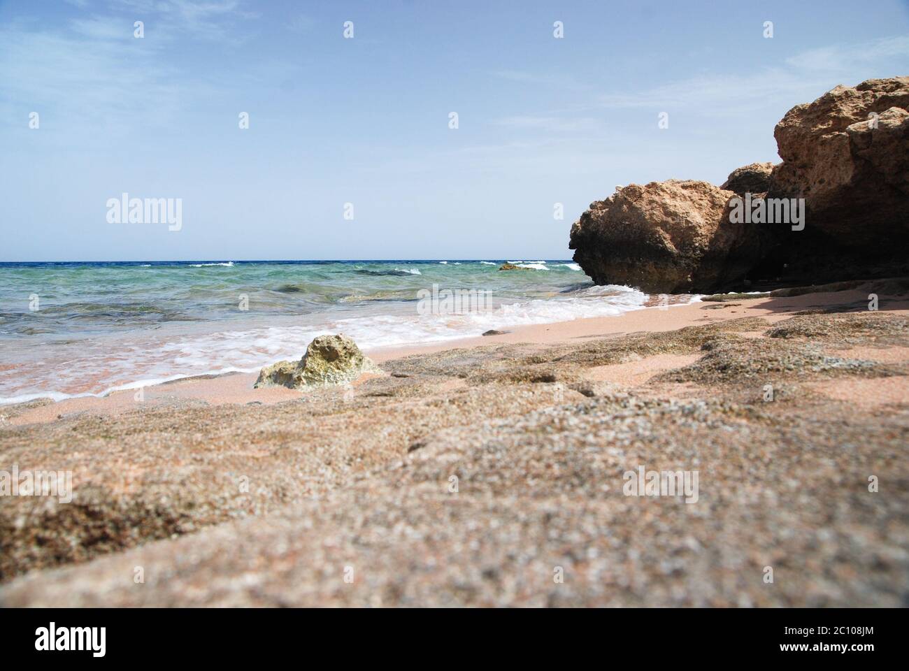 Foto di bella turchese mare mare superficie dell'oceano con increspature onde basse su mare sabbia sfondo spiaggia, orizzontale Foto Stock