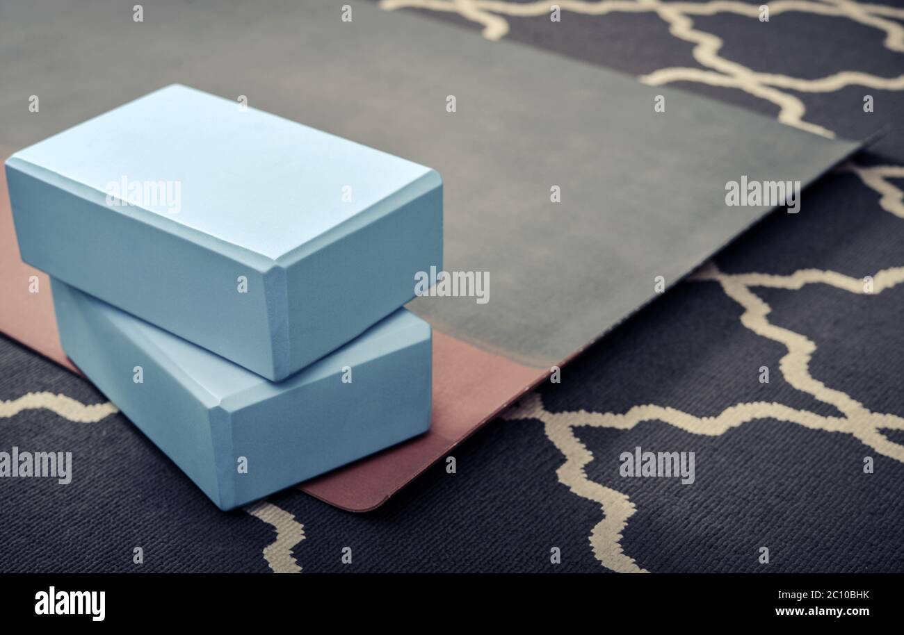 Tappetino yoga, bottiglia con acqua e mattoni yoga - accessori per la pratica di yoga domestico Foto Stock