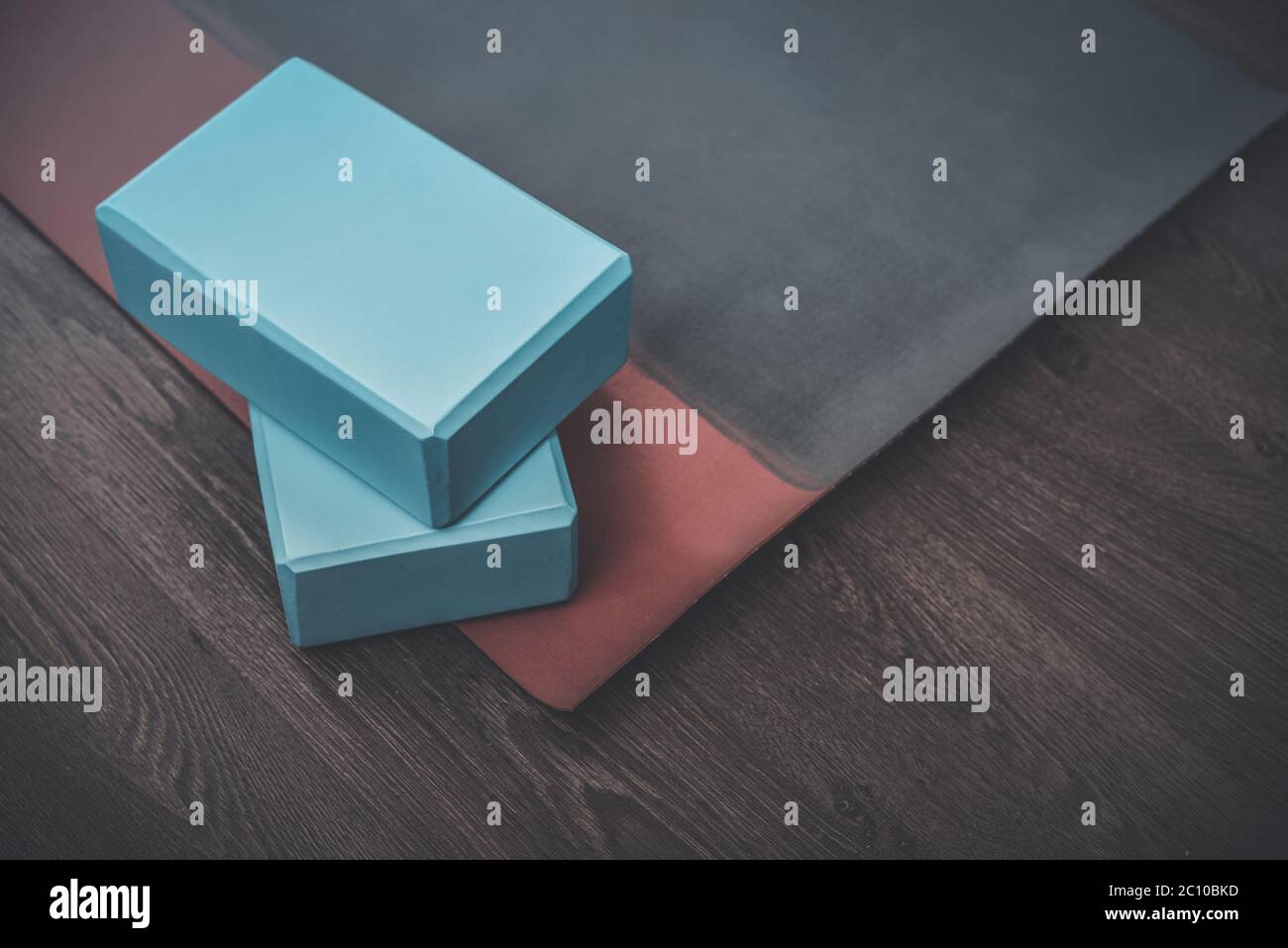 Tappetino yoga, bottiglia con acqua e mattoni yoga - accessori per la pratica di yoga domestico Foto Stock