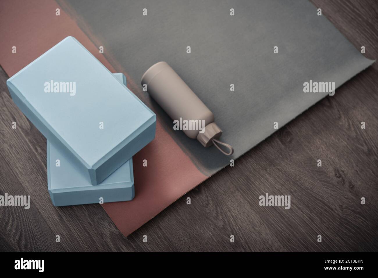 Tappetino yoga, bottiglia con acqua e mattoni yoga - accessori per la pratica di yoga domestico Foto Stock