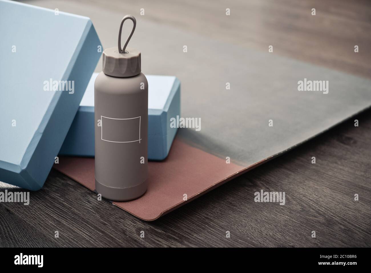 Tappetino yoga, bottiglia con acqua e mattoni yoga - accessori per la pratica di yoga domestico Foto Stock