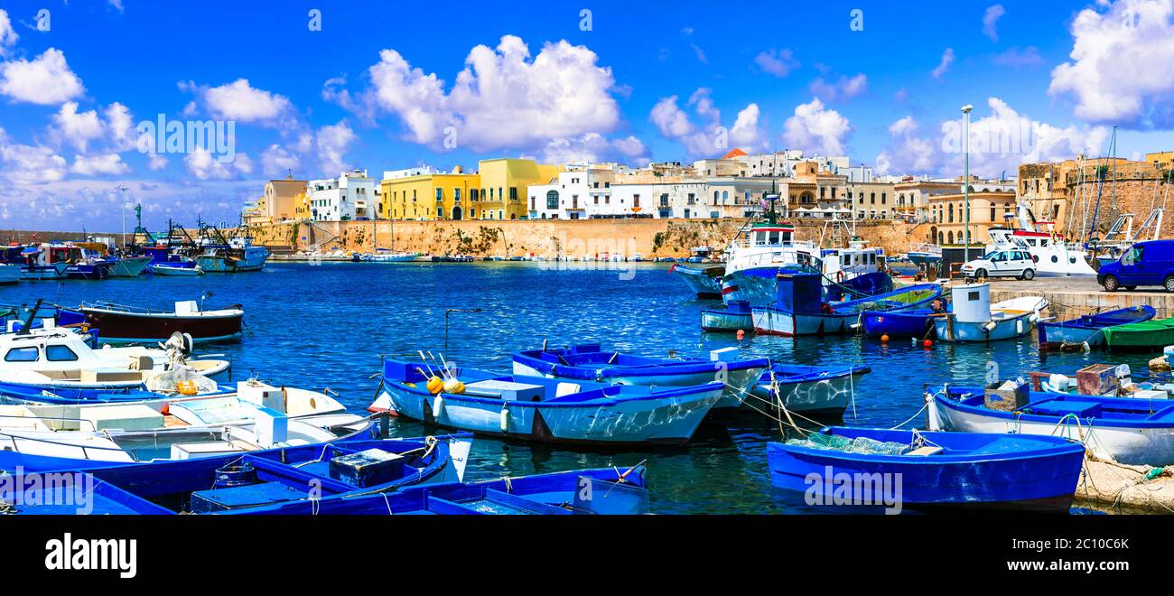 Italia viaggi. Gallipoli, vista sul castello medievale e sul porto con barche da pesca Foto Stock