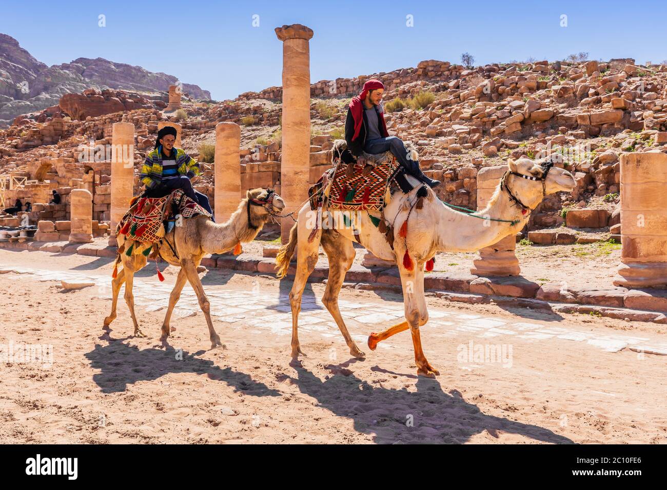 Petra, Giordania - 4 marzo 2020: Cavalieri di cammelli al Grande Tempio del Regno Nabateo. Foto Stock