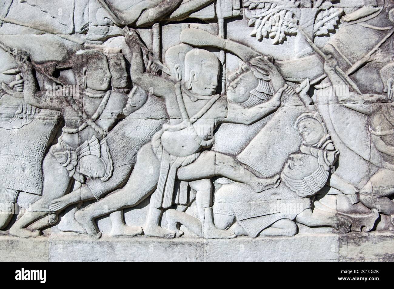 Antica scultura in bassorilievo Khmer che mostra un soldato Khmer che sta per uccidere un soldato Cham. Parete esterna del Tempio di Bayon, parte del complesso di Angkor Thom, si Foto Stock