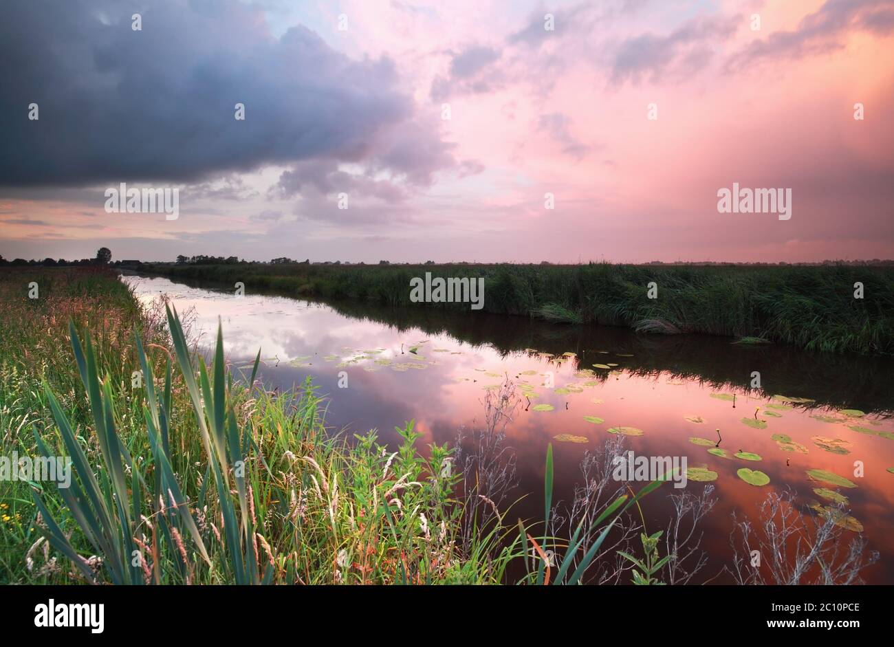 tramonto piovoso sul fiume Foto Stock