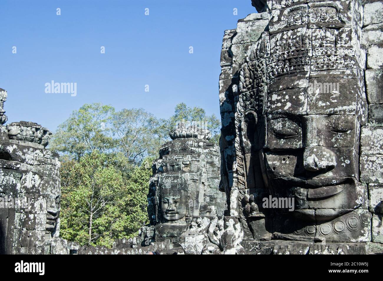 Vista in cima al tempio di Bayon, Cambogia, dei volti scolpiti sulle torri di questo antico monumento Khmer. Angkor Thom, Siem Reap, Cambogia. Foto Stock