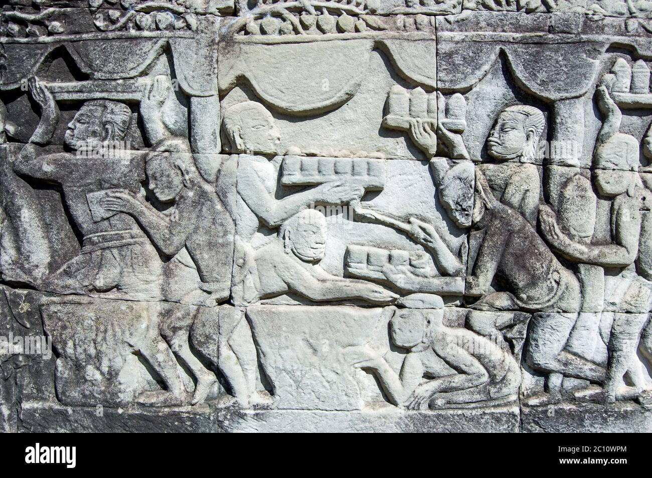Antica scultura Khmer che mostra vassoi di cibo e bevande che vengono portati a un banchetto. Muro del tempio di Bayon, Angkor Thom, Siem Reap, Cambogia. Foto Stock