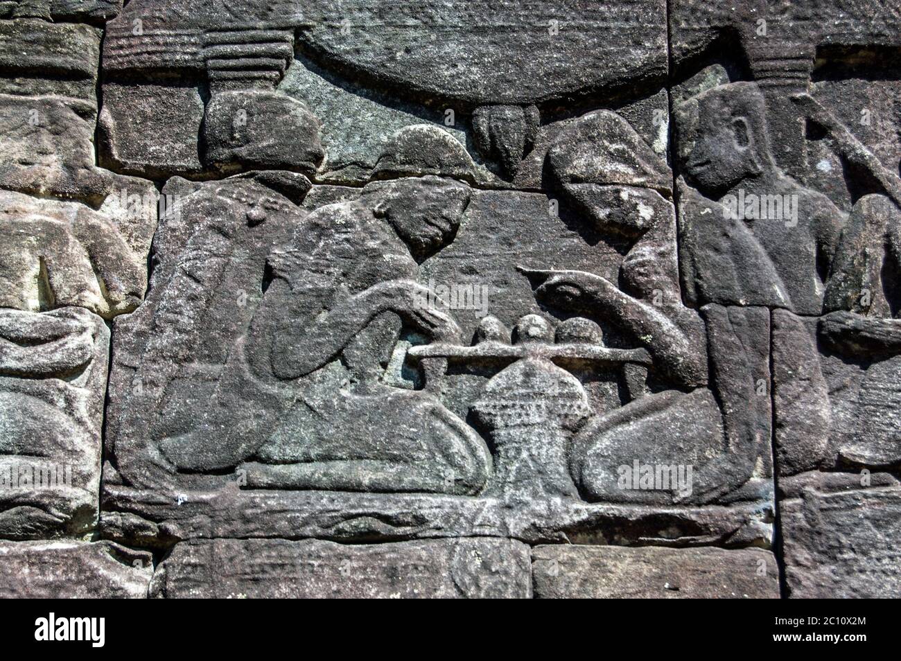 Antico fregio di bassorilievo Khmer che mostra due uomini che giocano a scacchi. Muro del tempio di Bayon, Angkor Thom, Siem Reap, Cambogia. Foto Stock