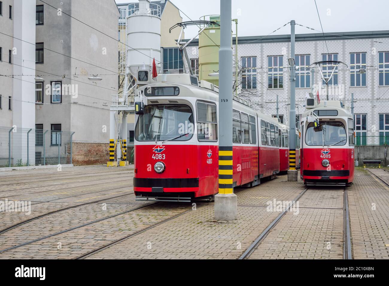 Due tram rossi articolati Vienna 4083 e 4085, costruiti negli anni '70 ancora in uso, parcheggiati in un deposito di tram, Vienna, Austria. Foto Stock