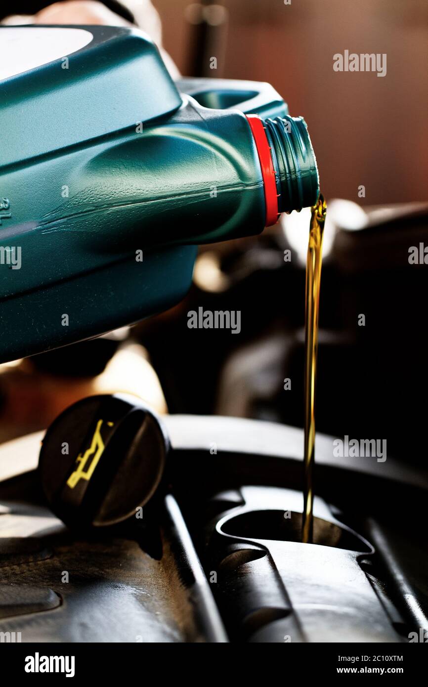 Olio fresco che viene versato durante un cambio dell'olio per un auto Foto Stock Olio fresco che viene versato durante un cambio dell'olio per un auto Foto Stock