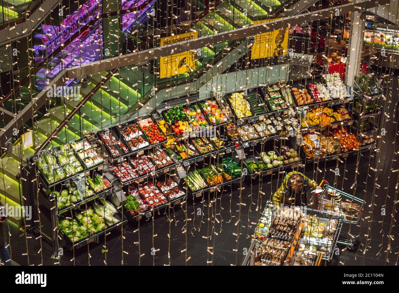 Stand di verdure e decorazioni incandescenti durante le vacanze di Natale in un mercato interno piuttosto una festa per gli occhi da alto, Vienna, Austria Foto Stock