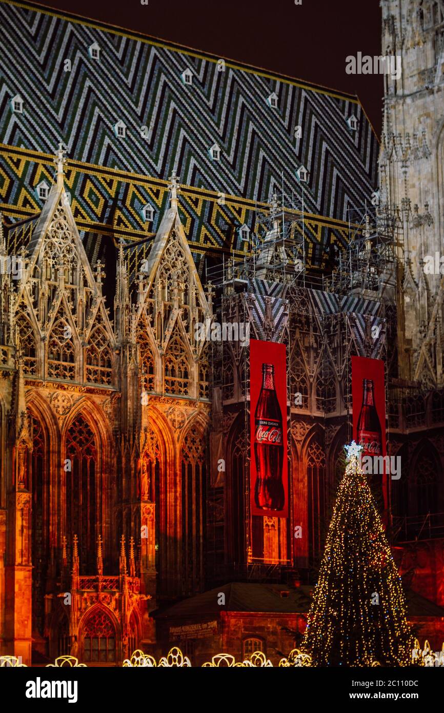 Cattedrale di Santo Stefano (Stephansdom) illuminata in luce rossa e la pubblicità Coca Cola posto su di essa. Mercatino di Natale a Stephansplatz. Foto Stock
