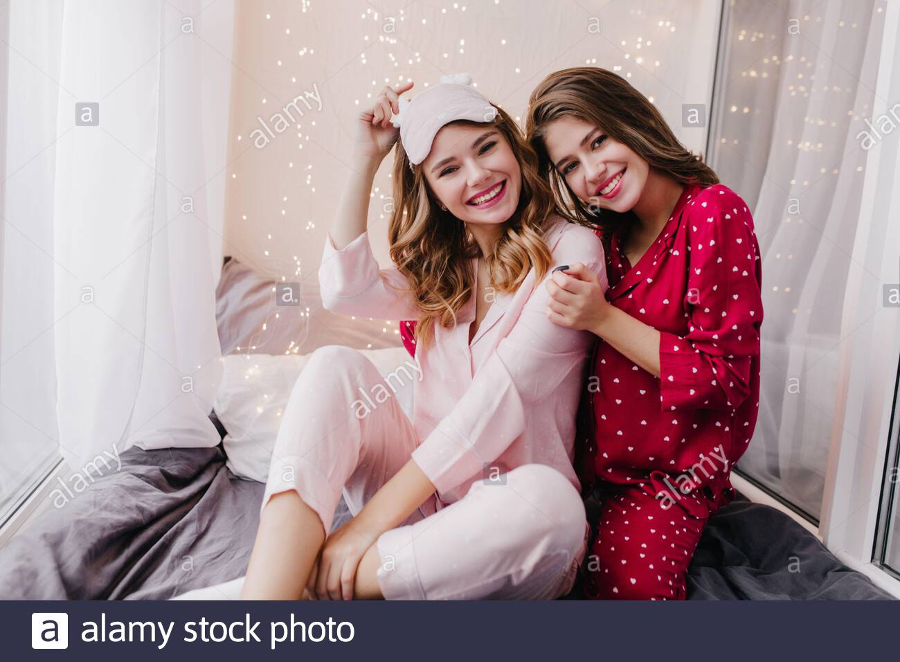 Affascinante Ragazza Riccia Seduta Con Gambe Piegate Sul Suo Letto E Sorridente Ritratto Di Belle Signore Dai Capelli Scuri Abbracciando Nel Buon Fine Settimana Mattina Foto Stock Alamy