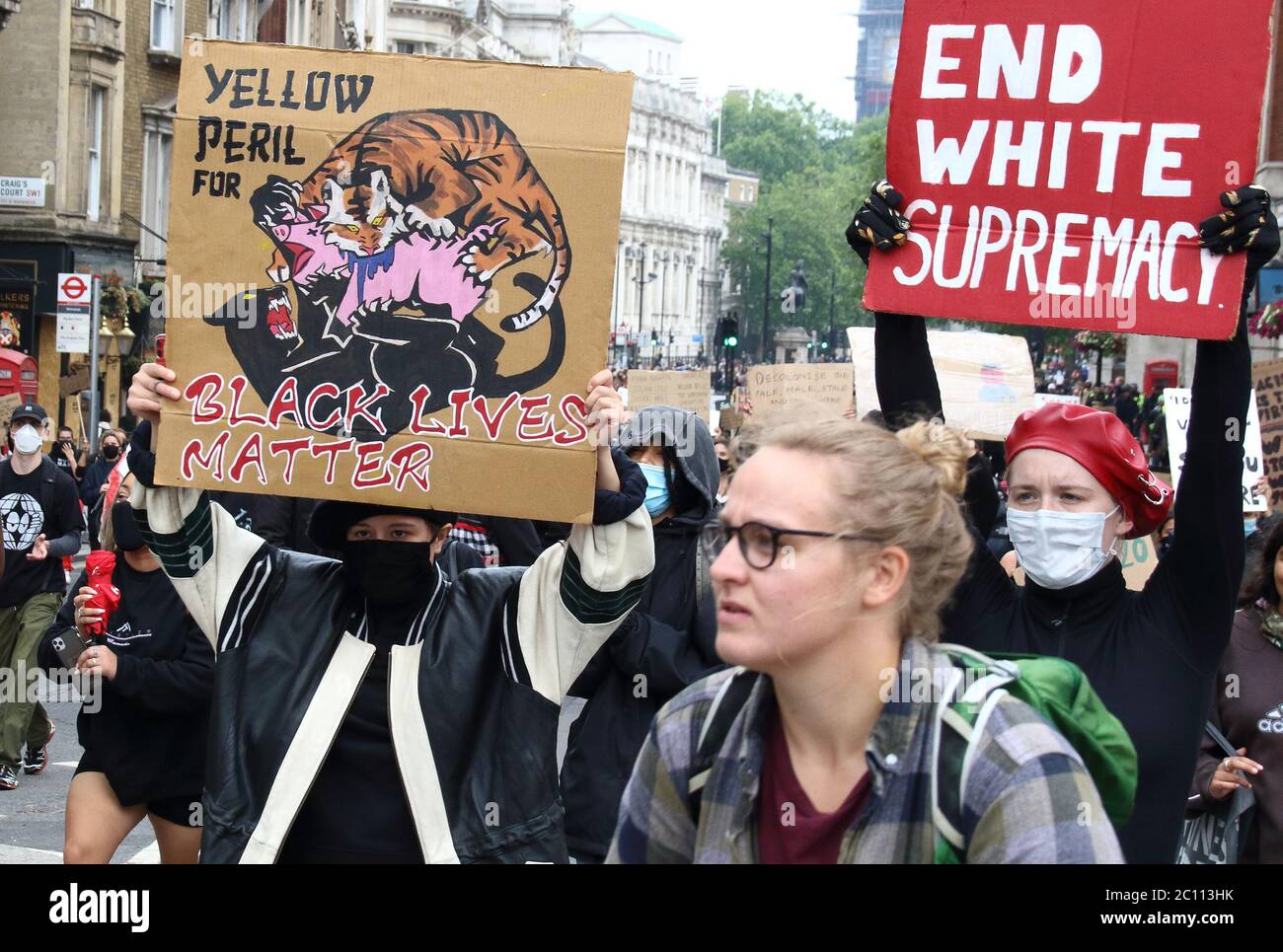 Un manifestante bianco con una maschera mostra la sua targa leggendo ' END WHITE SUPREMACY' durante le proteste BLM.i manifestanti marciano lungo Whitehall fino a Trafalgar Square alla fine delle ultime proteste per la materia Black Lives a Londra. Foto Stock