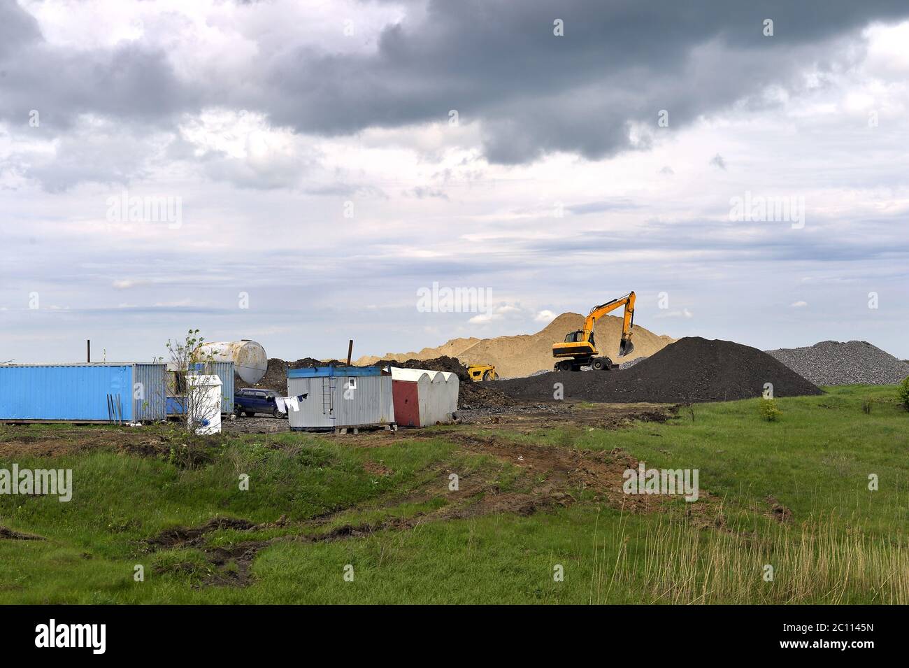 Escavatore giallo lavorando a scavare nella cava di sabbia Foto Stock