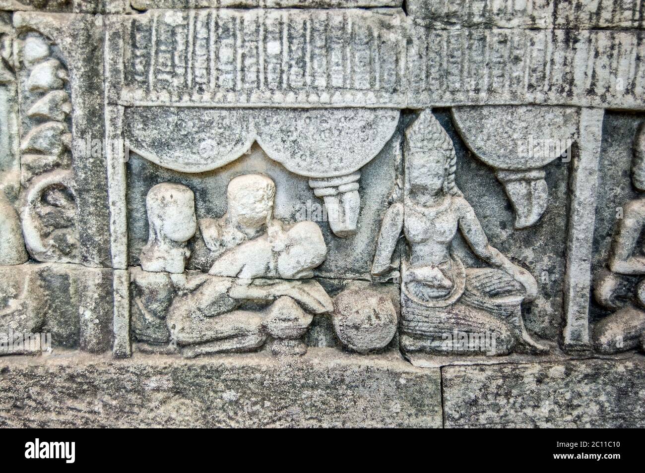 Antica scultura in bassorilievo che mostra una donna che riceve il massaggio Khmer. Muro del tempio di Bayon, Angkor Thom, Siem Reap, Cambogia. Foto Stock