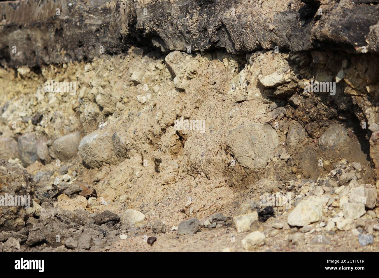 Strati nel terreno, raccontando la storia della costruzione della strada a Gatchina. Strato visibile macerie di pietra età 250 anni - t Foto Stock