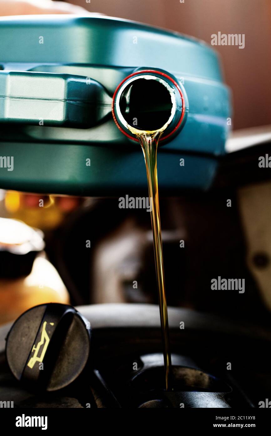 Olio fresco che viene versato durante un cambio dell'olio per un auto Foto Stock Olio fresco che viene versato durante un cambio dell'olio per un auto Foto Stock
