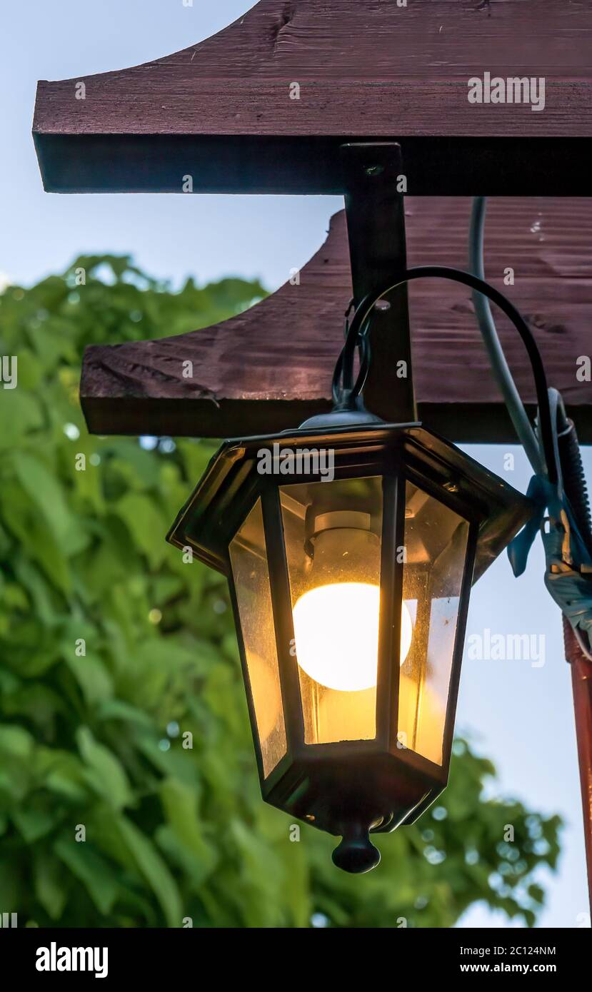 Lampada da strada vintage o lampada appesa davanti a un muro di mattoni rossi Foto Stock