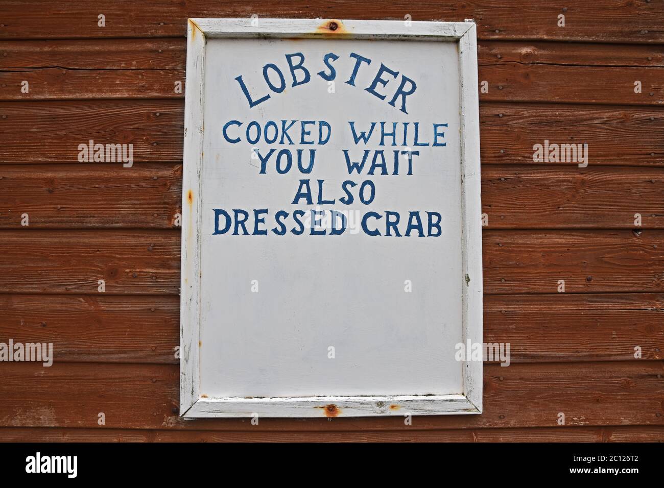 Autentico segno - aragosta cucinata mentre si aspetta anche granchio vestito. Preso a Coral Harbour, East Neuk di Fife, Scozia, Regno Unito. Foto Stock