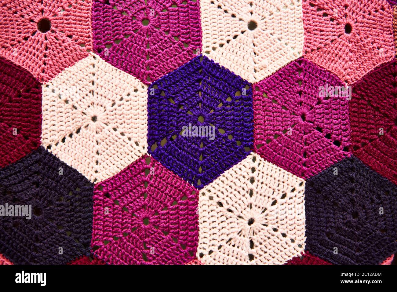 Primo piano di un colorato motivo a crochet esagonale lavorato a maglia. Foto Stock