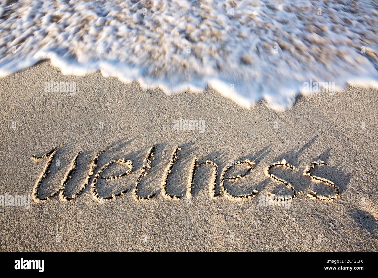 Concetto di benessere scritto sulla sabbia. Foto Stock