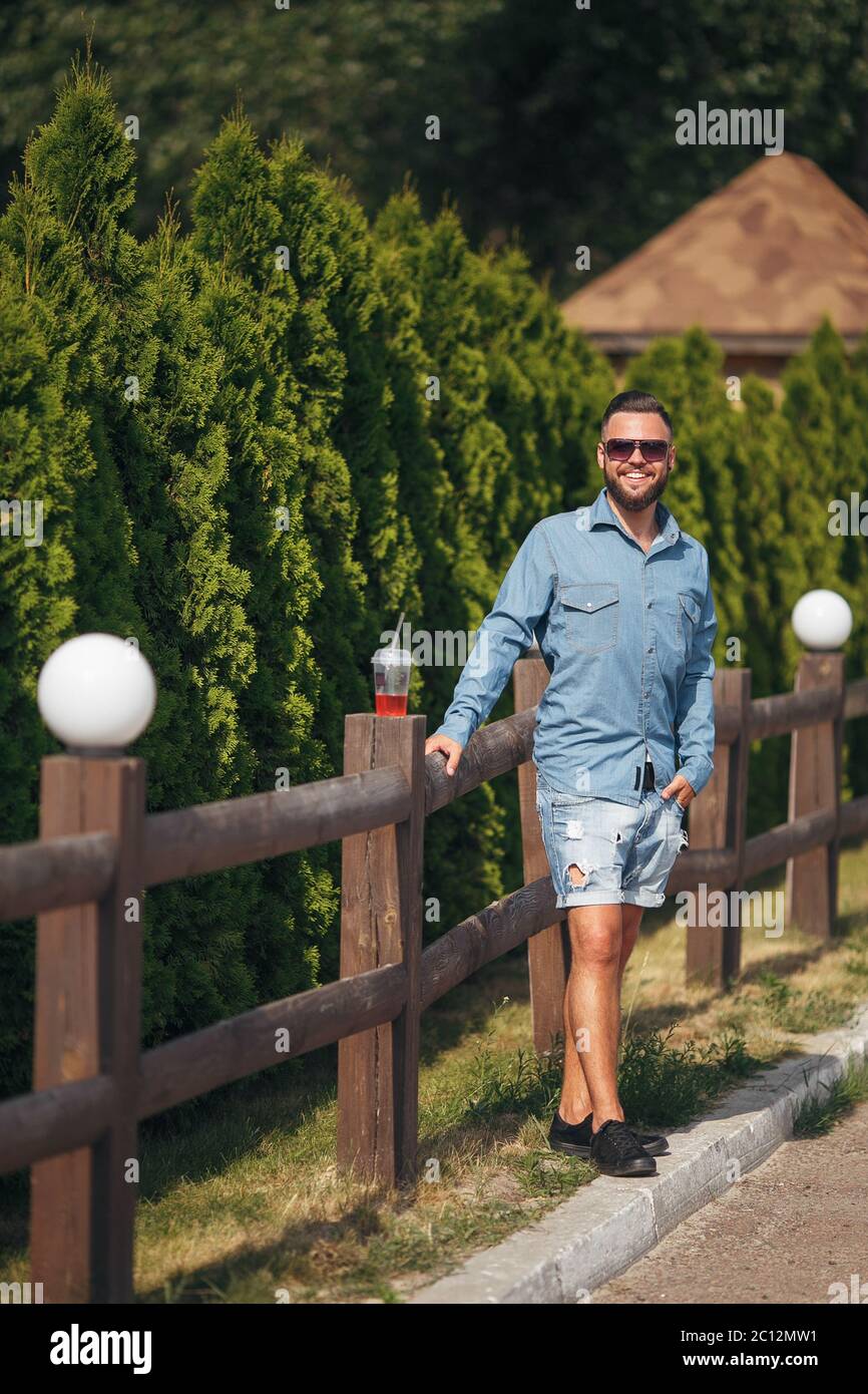 Un giovane uomo che cammina nel parco con la limonata in primavera. Giorno di primavera. Foto Stock