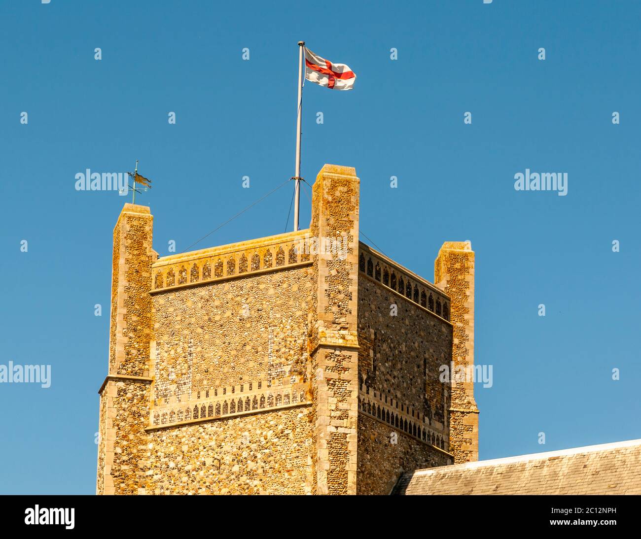 La bandiera inglese svetta su una massiccia torre nel Suffolk orientale, Inghilterra Foto Stock