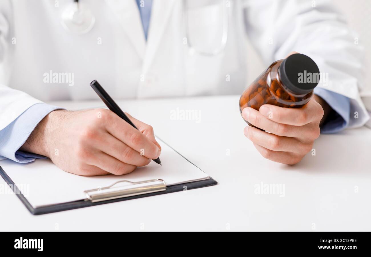 Medico maschile che scrive prescrizione medica per le pillole Foto Stock