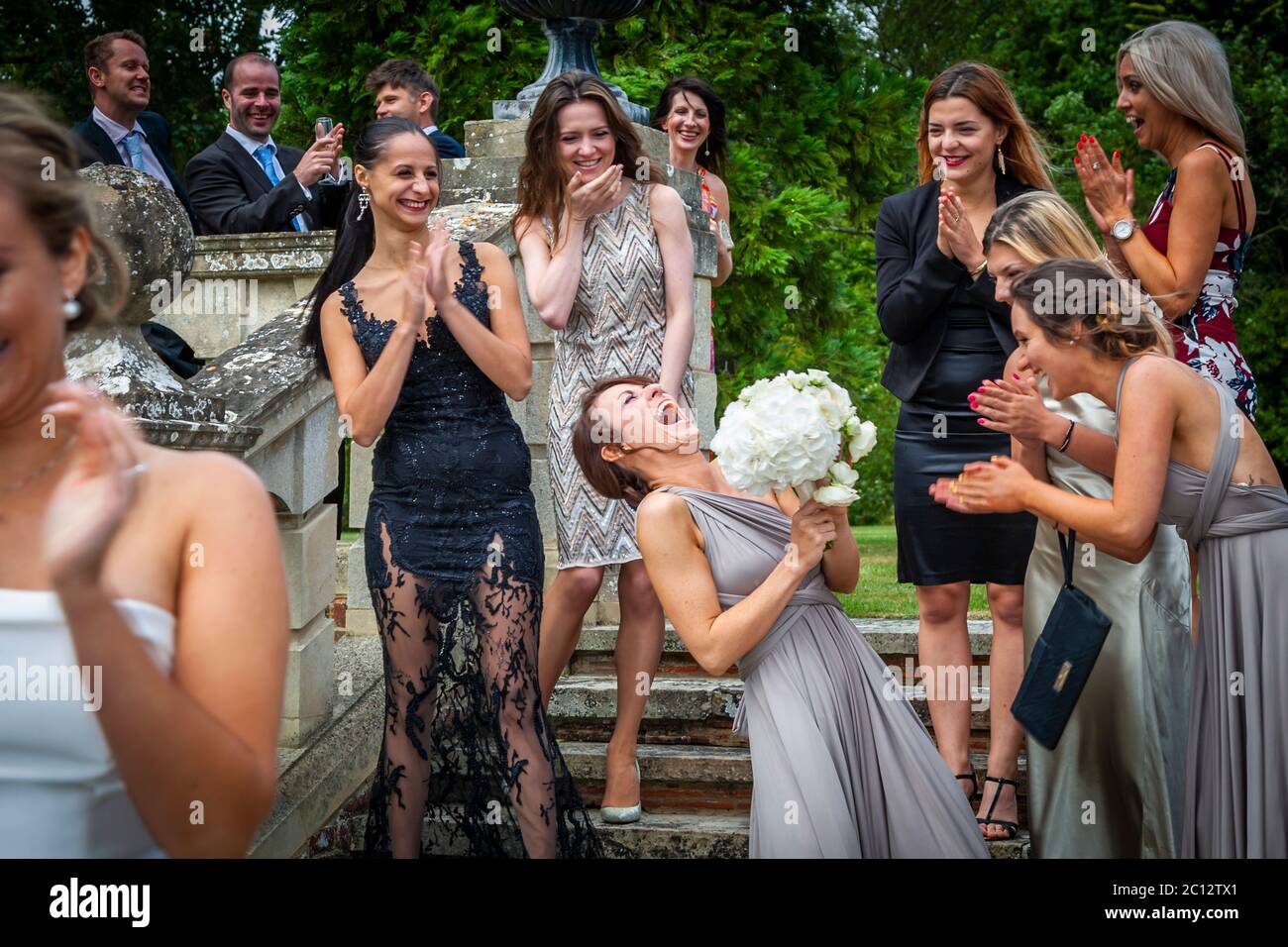 Chi catturerà il bouquet nuziale e sarà il prossimo ad ottenere hitched? Lancio del bouquet nuziale dopo il matrimonio a Sud Cambridgeshire, Inghilterra Foto Stock