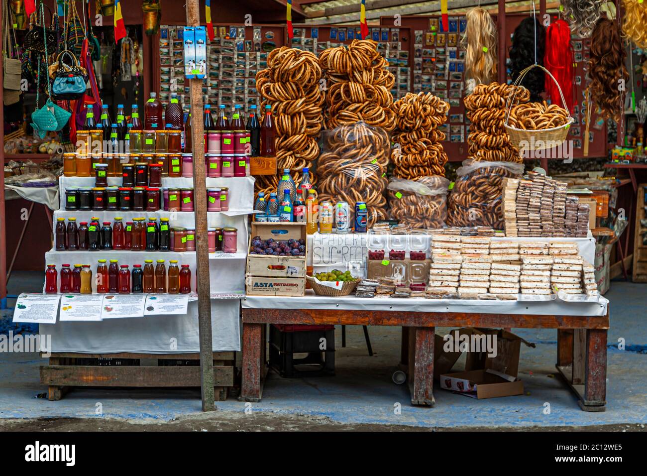 Uno stand di strada rumeno vende covrigi, gli anelli di pretzel tradizionali rumeni, insieme a barattoli di marmellata e miele, oltre a pasticcini piatti. Piccole bandiere rumene adornano la vetrina. Foto Stock