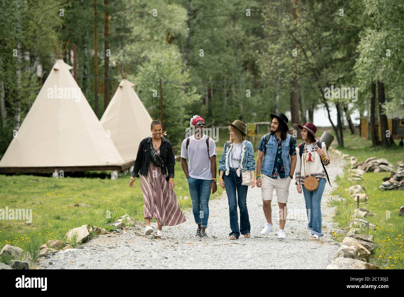 Gruppo di giovani multietnici arrivati al campeggio a piedi sul bellissimo parco Foto Stock