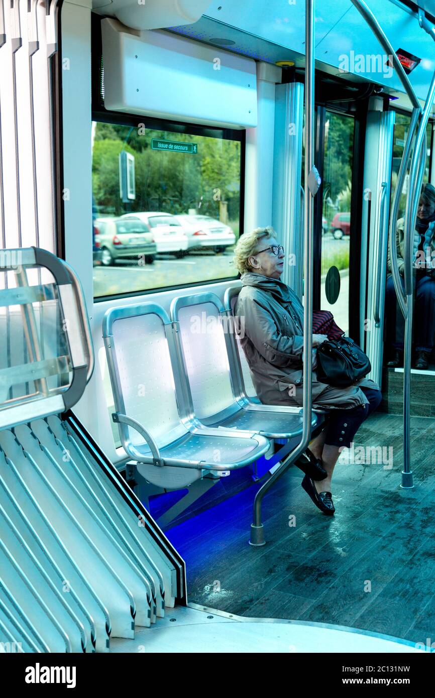 Anziana donna seduta su un autobus futuristico con posti illuminati, Biarritz, Francia Foto Stock