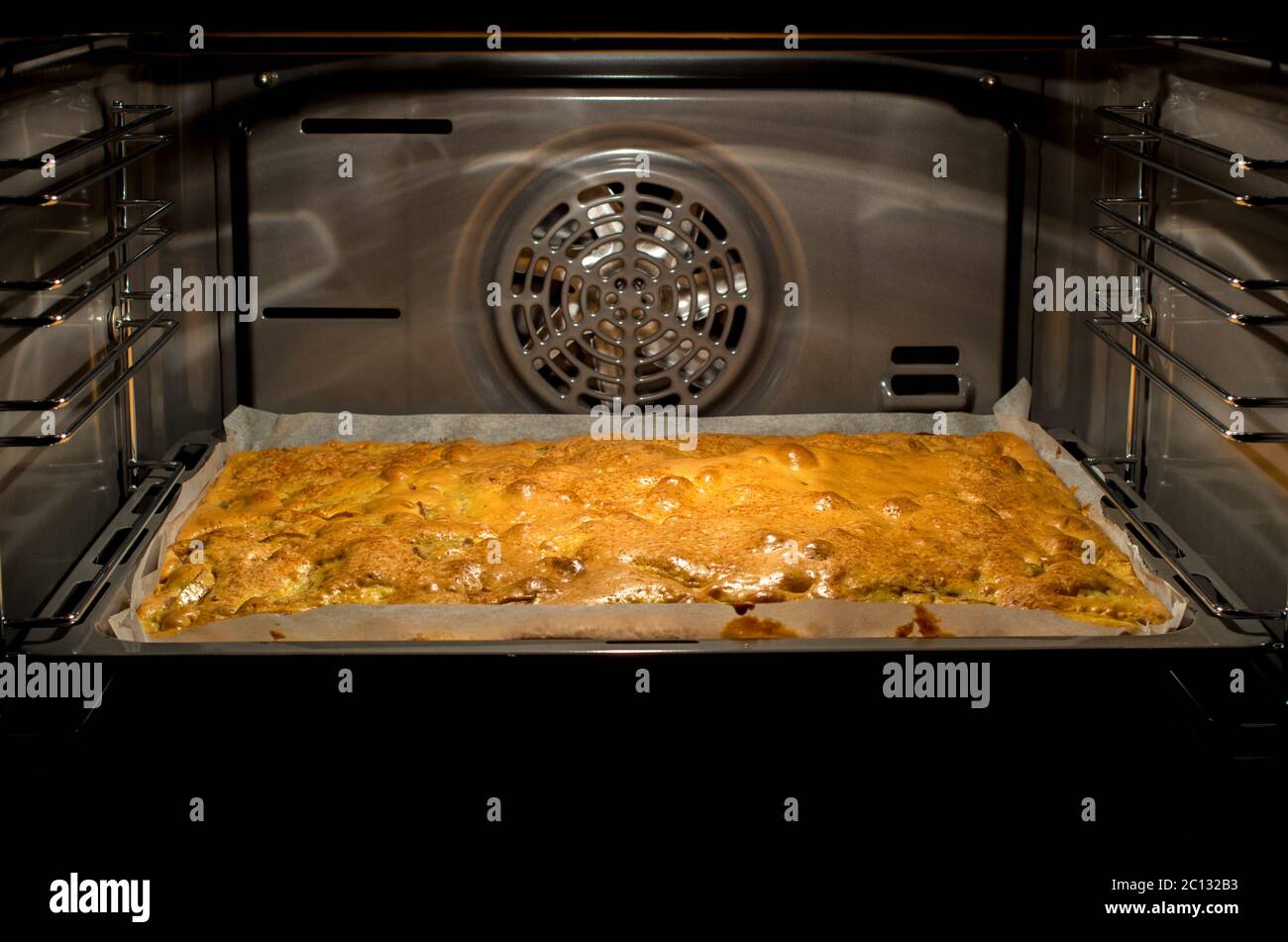 Primo piano della torta di mele in teglia nel forno aperto Foto Stock