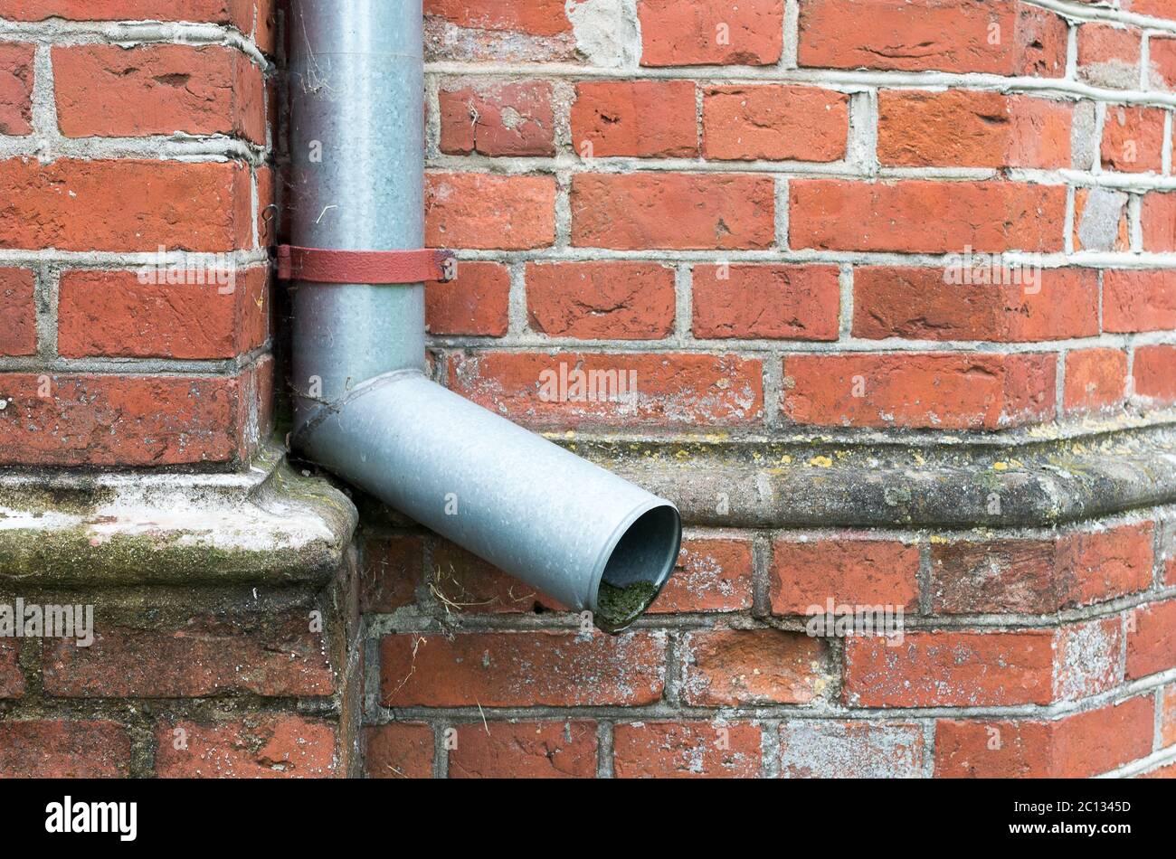Il vecchio tubo discendente al muro di mattoni rossi. Foto Stock