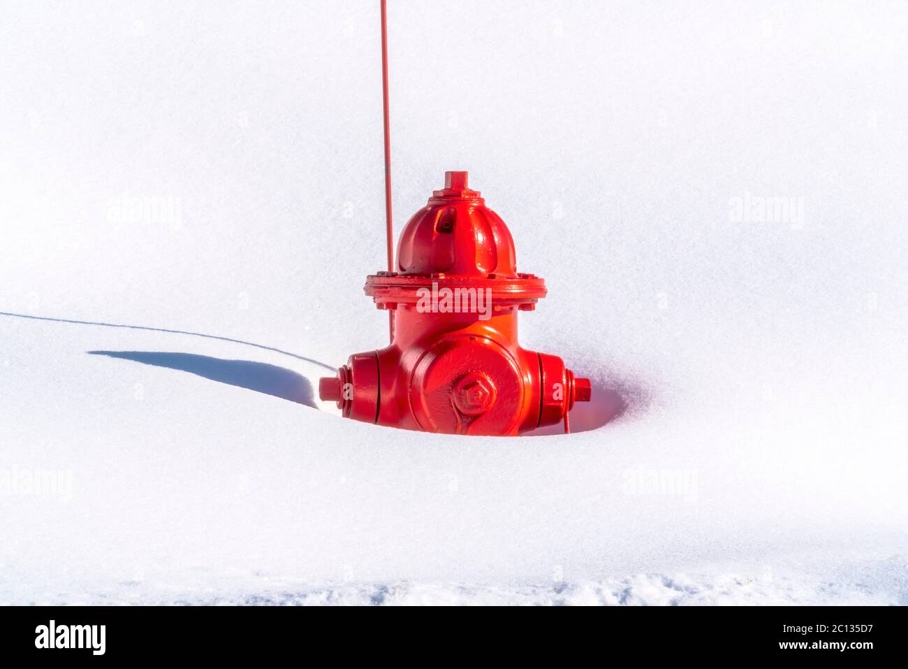 Idrante rosso fuoco vibrante sepolto nella neve durante l'inverno a Park City Utah Foto Stock